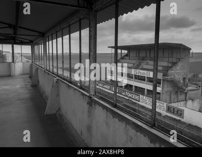 Reims-Gueux, Frankreich 08/11/2017 die alten stillgebrauchten Tribünen auf dem Circuit de Reims mit Autos, die sich auf der alten Strecke nähern, wie sie es in y getan hätten Stockfoto