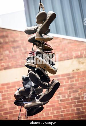 Hängende Schuhe an einer Linie. An der AC/DC Lane in Melbourne, Vic, Australien Stockfoto