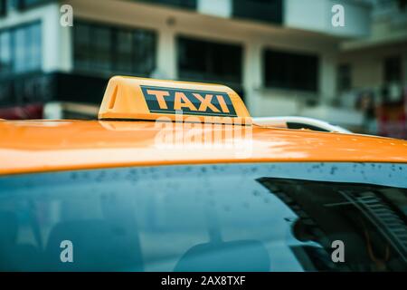 Nahaufnahme des gelben Taxizeichens auf dem Dach eines Autos. Transport- und Reisekonzept Stockfoto