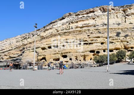 Matala, Griechenland - 07. Oktober 2018: Nicht identifizierte Menschen am Strand und an alten Gräbern auf dem Hügel Stockfoto