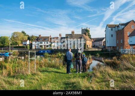 24. Oktober 2018 - Tewkesbury, Großbritannien: Drei Männer stehen mit Angelausrüstung vor einer malerischen Gruppe von Hütten, die sich im ruhigen Fluss Avon in der Nähe von Abbey Mill in der Stadt Tewkesbury, Gloucestershire, Severn Vale, Großbritannien, spiegeln Stockfoto