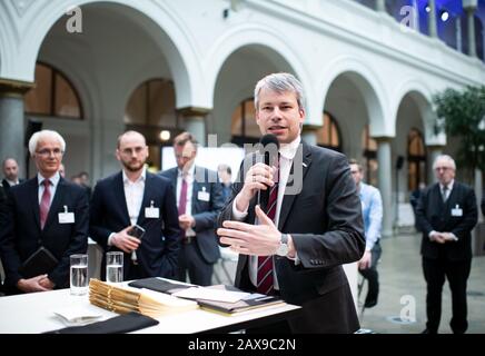 11. Februar 2020, Berlin: Steffen Bilger (CDU, r), Parlamentarischer Staatssekretär im Bundesverkehrsministerium und Digitale Infrastruktur, übergibt Förderbescheide für den Kauf von E-Fahrzeugen und verlangte Gebührenanlagen an Vertreter zahlreicher Regionen im Bundesverkehrsministerium und der digitalen Infrastruktur. Im Rahmen des Sofortaktionsprogramms "Clean Air 2017-2020" stehen insgesamt 265 Millionen Euro für die Beschaffung von Elektrofahrzeugen und der damit verbundenen Ladeinfrastruktur für die Kommunen zur Verfügung. Foto: Bernd von Jutrczenka / dpa Stockfoto