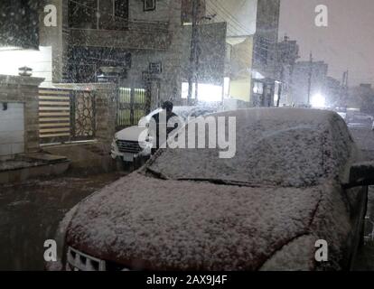 (200211) - BAGDAD, 11. Februar 2020 (Xinhua) - ein Mann spaziert in Bagdad, Irak, 11. Februar 2020 im Schnee. Viele Menschen in der irakischen Hauptstadt Bagdad wachten am frühen Dienstag auf, um einen seltenen Schneefall in der Stadt zu beobachten. Im Norden des Landes, insbesondere in den Berggebieten, wird im Irak häufig Schnee gesehen. Für die meisten Bürger in Bagdad ist es selten, dass sie Schnee sehen. Bagdad erlebte im Januar 2008 zum ersten Mal seit über 100 Jahren einen Schneefall. (Xinhua/Khalil Dawood) Stockfoto