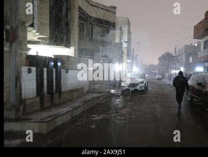 (200211) - BAGDAD, 11. Februar 2020 (Xinhua) - ein Mann spaziert in Bagdad, Irak, 11. Februar 2020 im Schnee. Viele Menschen in der irakischen Hauptstadt Bagdad wachten am frühen Dienstag auf, um einen seltenen Schneefall in der Stadt zu beobachten. Im Norden des Landes, insbesondere in den Berggebieten, wird im Irak häufig Schnee gesehen. Für die meisten Bürger in Bagdad ist es selten, dass sie Schnee sehen. Bagdad erlebte im Januar 2008 zum ersten Mal seit über 100 Jahren einen Schneefall. (Xinhua/Khalil Dawood) Stockfoto