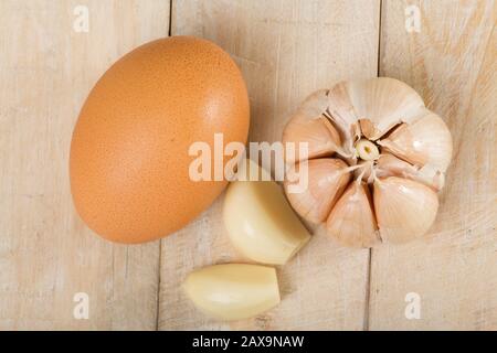 Hühner- und Knoblaucheier auf dem Holztisch. Stockfoto