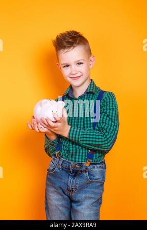 Finanzielle Kompetenz der Kinder. Glückliches Kind mit Moneybox Stockfoto