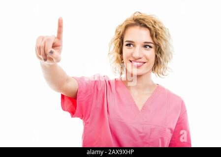 Porträt der jungen Krankenschwester, die mit einem auf weißem Hintergrund isolierten Touchscreen pinkfarben schrubbt Stockfoto