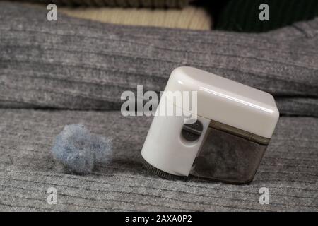 Entfernen von Flusen (Pilling) aus der Pullover. Gerät und gesammelte Flusen. Stockfoto