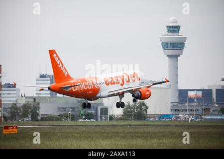 Easy Jet Airplane, Start am Flughafen Amsterdam Schiphol, mit Kontrollturm im Hintergrund Stockfoto