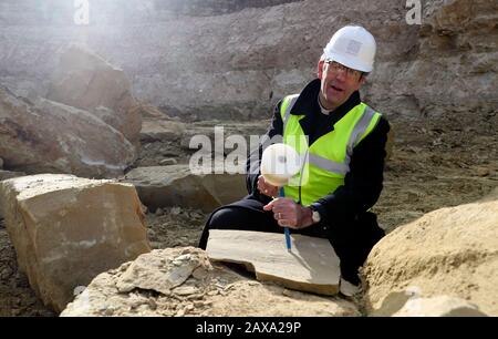 Der Dekan von Salisbury, der Revd Nicholas Papadopulos, untersucht einen Stein im Chicksgrove Quarry in Tisbury, Wiltshire, vor dem launchÊon Dienstag 18 FebruaryÊofÊSalisbury 2020, City on the Move, ein Jahr lang Feiern zum 800-jährigen Jubiläum der Kathedrale. Der Stein wird zum Gedenken an den Umzug der Kathedrale aus Dem Alten Sarum vor acht Jahrhunderten gehauen und am östlichen Ende der Kathedrale von Salisbury befestigt. Stockfoto