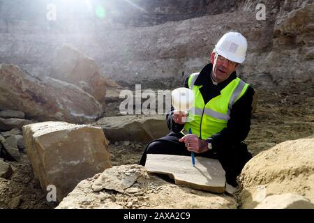 Der Dekan von Salisbury, der Revd Nicholas Papadopulos, untersucht einen Stein im Chicksgrove Quarry in Tisbury, Wiltshire, vor dem launchÊon Dienstag 18 FebruaryÊofÊSalisbury 2020, City on the Move, ein Jahr lang Feiern zum 800-jährigen Jubiläum der Kathedrale. Der Stein wird zum Gedenken an den Umzug der Kathedrale aus Dem Alten Sarum vor acht Jahrhunderten gehauen und am östlichen Ende der Kathedrale von Salisbury befestigt. Stockfoto