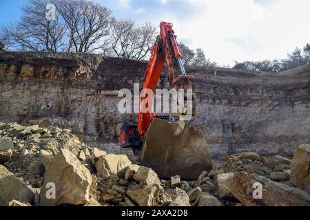 Ein Bagger arbeitet im Chicksgrove Quarry in Tisbury, Wiltshire, wo Der Dekan von Salisbury, Der Gerade Revd Nicholas Papadopulos, einen Stein vor dem launchÊon Dienstag 18 FebruaryÊofÊSalisbury 2020 segnete, City on the Move, ein Jahr lang Feiern zum 800-jährigen Jubiläum der Kathedrale. Der Stein wird zum Gedenken an den Umzug der Kathedrale aus Dem Alten Sarum vor acht Jahrhunderten gehauen und am östlichen Ende der Kathedrale von Salisbury befestigt. Stockfoto