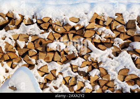 Brennholz schneiden Winterbrennstoff Holzstapel. Gestapeltes Winterbrennholz. Brennholz bedeckt mit Schnee in der Region Leningrad. Russland. Stockfoto