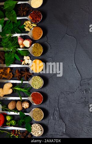 Verschiedene Gewürze und Kräuter auf schwarzem Hintergrund Stockfoto