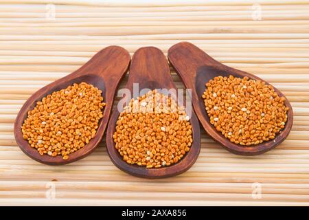 Rote Hirsekörner mit Holzlöffel. Stockfoto