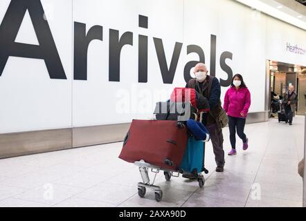 Passagiere, die Masken tragen, kommen am Terminal 4 Heathrow an.Es gibt ein großes Gefühl der öffentlichen Gesundheit mit der Zahl der Todesopfer für Coronavirus, die steigt. Stockfoto