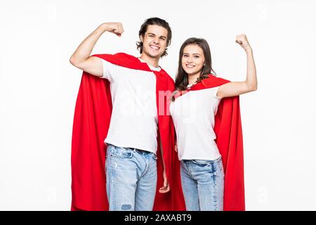 Junge Paare tragen in Superheldencout zeigen die auf Weiß isolierte Kraft Stockfoto