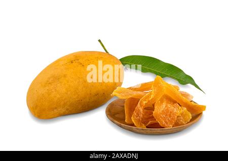 Haufen dehydrierter Mango in Holzplatte und reifer Mango mit grünem Blatt auf weißem Grund mit Schneideweg. Stockfoto