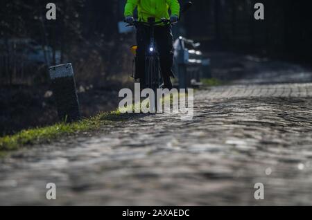 Trebur, Deutschland. Januar 2020. Ein Radfahrer fährt auf einer holprigen gepflasterten Straße. Kredit: Andreas Arnold / dpa / Alamy Live News Stockfoto