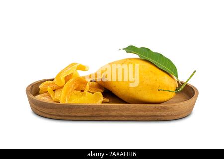 Haufen dehydrierter Mango und reifer Mango mit Blatt in einer Holzschale auf weißem Grund mit Schneideweg. Stockfoto
