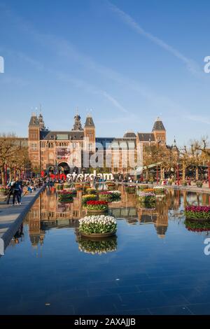 Museumplein-Landschaft mit blühenden Tulpen vor dem Rijksmuseum und dem Amsterdamer Schild Amsterdam, Niederlande Stockfoto