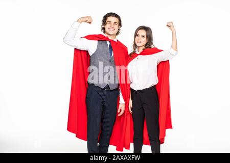 Super Paar in Masken und Kleider stehen mit verschränkten Armen und Kamera isoliert auf Grau Stockfoto