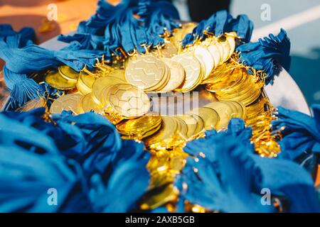 Viele Goldmedaillen mit Bändern. Goldene Medaillen für Gewinner des Fußballwettbewerbs Stockfoto