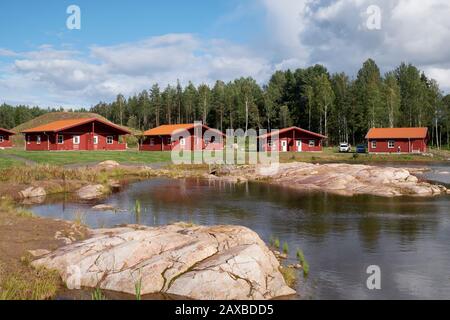 Rot lackierte Holz-Chalets am See in der Kosta Lodge Stockfoto