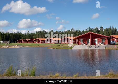 Rot lackierte Holz-Chalets am See in der Kosta Lodge Stockfoto