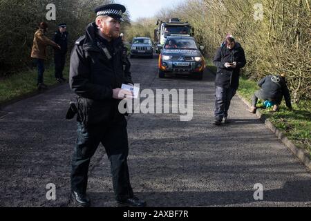 Denham, Großbritannien. Februar 2020. Ein Thames Valley Polizist läuft mit einem Buch mit dem Titel "Antiterrorpolicing", nachdem er eine Warnung ausgegeben hat, die es einem Umweltaktivisten vom Extinction Rebellion verwendet hat, der vor einem LKW, der einen JCB-Gabelstapler an einen HS2-Standort liefert, "zu Fuß Gelaufen" war. Der Aktivist wurde daraufhin verhaftet. Credit: Mark Kerrison/Alamy Live News Stockfoto