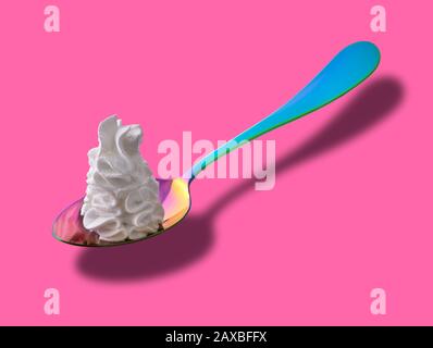 Bunte Löffel mit Peitschencreme auf pinkfarbenem Hintergrund Stockfoto