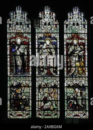 Ein Glasfenster von C E Kempe & Co. Ltd, das St Luke, The Holy Mother and Child & St. John, St Editha's Church, Church Eaton, Staffordshire darstellt Stockfoto