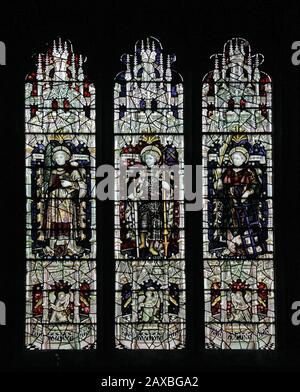 Ein Glasfenster von C E Kempe & Co. Ltd. Mit den Heiligen Stephen, Alban und Lawrence, St Editha's Church, Church Eaton, Staffordshire Stockfoto