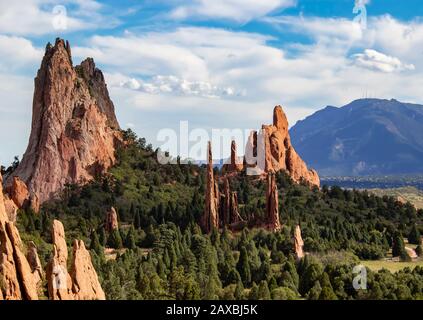 Die hoch aufragenden roten Felsformationen des Garden of the Gods of Colorado Springs mit dem Cheyenne Mountain im Hintergrund Stockfoto