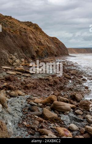 Eine zerklüftete felsige Küste auf der Insel Wight, die bei Flut Anzeichen von Küstenerosion auf den Klippen zeigt. Stockfoto