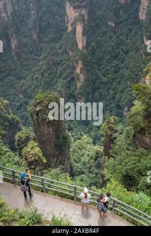 Zhangjiajie, China - August 2019: Touristen, die auf dem Bezaubernden Aussichtspunkt auf der Terrasse, dem Naturpark Avatar Mountains, Fotos auf Mobiltelefonen machen Stockfoto