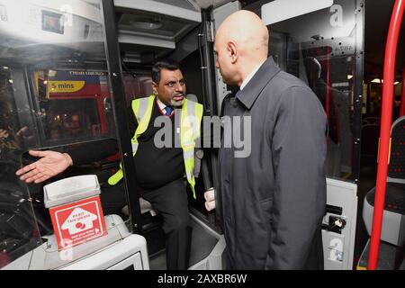 Schatzkanzler Sajid Javid spricht bei einem Besuch in der zentralen Buswerkstatt von Birmingham mit einem Busfahrer Mohamed Shafiq. Stockfoto