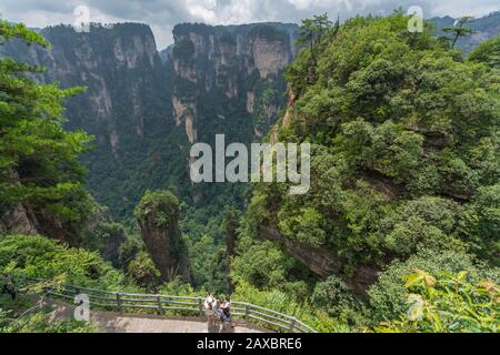 Zhangjiajie, China - August 2019: Touristen, die auf dem Bezaubernden Aussichtspunkt auf der Terrasse, dem Naturpark Avatar Mountains, Fotos auf Mobiltelefonen machen Stockfoto