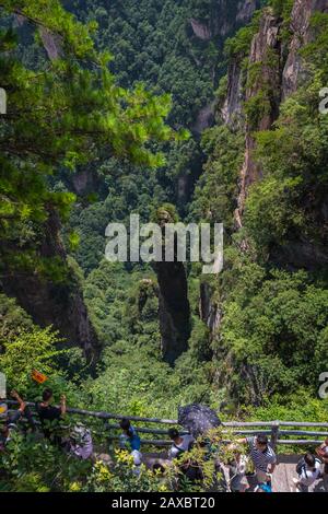 Zhangjiajie, China - August 2019: Touristen, die auf Mobiltelefonen Fotos machen, auf dem Aussichtspunkt der Größten Natürlichen Brücke, auch bekannt als Tian Qiao S Stockfoto