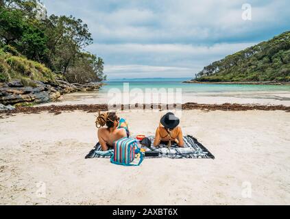 Ein paar Sonnenbaden am abgelegenen tropischen Meeresstrand Jervis Bay Australia Stockfoto