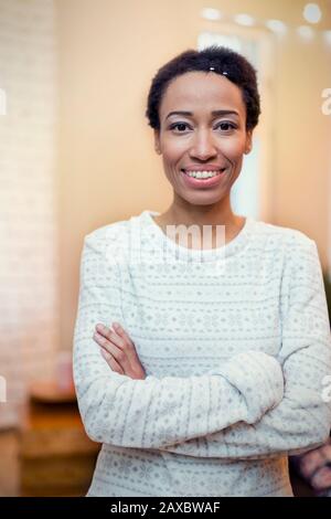 Portrait selbstbewusste, lächelnde Frau mit gekreuzten Armen Stockfoto