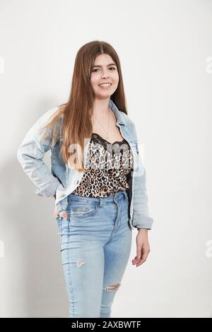 Portrait selbstbewusste junge Frau mit Denimjacke und Jeans Stockfoto