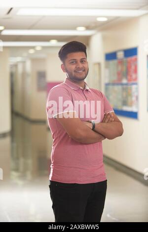 Portrait selbstbewussten jungen männlichen Studenten im Korridor Stockfoto
