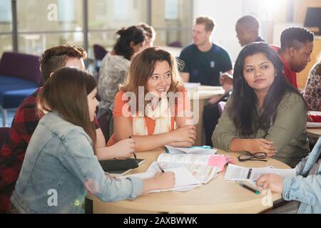 Studenten, die am Bibliothekstisch studieren und sprechen Stockfoto