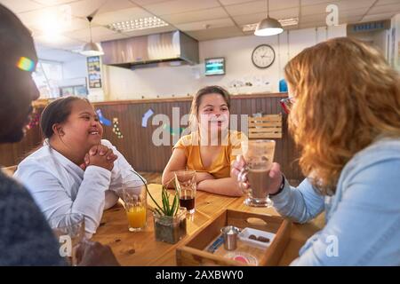 Junge Frauen mit Down-Syndrom sprechen mit Mentoren im Café Stockfoto