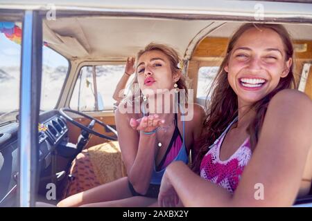 Portrait verspielte junge Frauen Freunde weht einen Kuss im Lieferwagen Stockfoto
