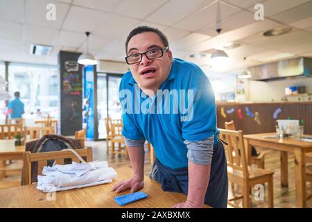 Portrait selbstbewusster junger Mann mit Down-Syndrom arbeitet im Café Stockfoto