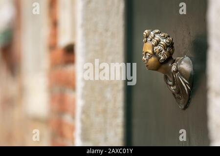 Abschluss eines Türgriffs aus Bronze an einer grünen Tür in Venedig (Italien) Stockfoto