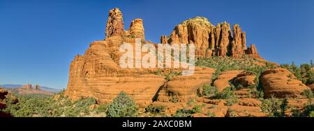 Zwei massive Buttes aus rotem Sandstein entlang des Chapel Trail in Sedona Arizona. Cathedral Rock ist auf der linken Seite in der Ferne zu sehen. Stockfoto