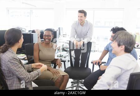 Glückliche Geschäftsleute sprechen, treffen sich im offenen Büro Stockfoto